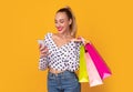 Happy woman holding cellphone and shopping bags Royalty Free Stock Photo