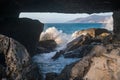 Looking through a space in the rocks to sea water crashing over rocks. La Pared, Fuerteventura