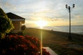 Looking at the Sunrise in the Bay of Southern Cebu. Waiting Shed, Grass, Flowers, Lamppost, Dog and Sunrays.