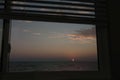 Looking at sunset thru a window with opened blinds Royalty Free Stock Photo