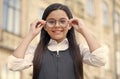 Looking to future. Happy kid fix eyeglasses outdoors. Eye sight development. Child vision. Back to school eye sight test Royalty Free Stock Photo