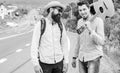 Looking for transport. Men edge road hitchhiking. Friends gathered to travel together. Travelers with backpack and Royalty Free Stock Photo