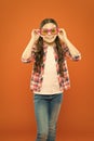 Looking trendy. Fashionable party girl on orange background. Adorable party girl wearing fancy glasses. Cute small child