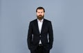 Looking trendy. handsome man standing on gray background. serious bearded businessman. stylish mature man looking modern