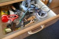 Looking into a untidy drawer. Messy drawer with tools, household items and various other objects