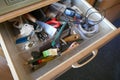 Looking into a untidy drawer. Messy drawer with tools, household items and various other objects