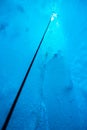 Looking up a climbing rope from deep inside an ice cave in the Salmon Glacier in Canada Royalty Free Stock Photo