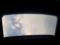 Looking up at a clouded sky heaven through car sun roof