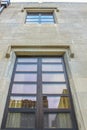 Looking up at a detail of a modern building with old art deco buildings reflected in its windows - perspective Royalty Free Stock Photo