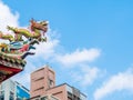 Looking up dragon sculpture on top of chinese temple roof against the blue sky and clouds with copy space. Royalty Free Stock Photo