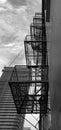 Looking up at fire escape attached to building as skyscraper is built in the distance Royalty Free Stock Photo