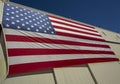 Looking up at a giant American flag on the side of a hangar building Royalty Free Stock Photo