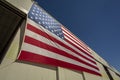 Looking up at a giant American flag on the side of a hangar building