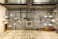 Looking up on gray concrete ceiling with halogen spots and edison lamps in loft office room with air conditioning and orange Royalty Free Stock Photo