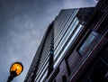 Looking up at a modern building and streetlight under a cloudy s Royalty Free Stock Photo