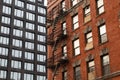 Old Brick Building with Fire Escapes next to a Modern Residential Skyscraper in Tribeca of New York City Royalty Free Stock Photo