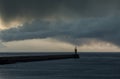 Looking up the River Tyne out to the North Sea at dawn, as large grey rain clouds loom over the Piers