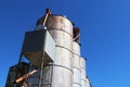 Looking up at a rusty old working agricultural feed grain and corn silo building against a blue sky in rural heartland america Royalty Free Stock Photo