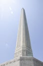 Looking up at the San Jacinto Monument with a dazzling sun behind it, and a clear blue sky