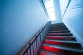 Looking up the scary distorted stairway. Stairs going up with red light on steps Royalty Free Stock Photo