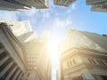 Looking up at the skyline buildings of Wall Street in New York City with sun shining above Royalty Free Stock Photo