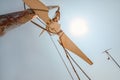 Looking up small broken wind turbine, strong midday sun shining in back