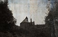 Looking up at a spooky church surrounded by trees in the countryside with a moody, vintage, grunge edit