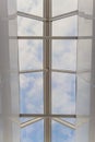 Looking up to the blue cloudy sky through modern square ceiling window. Royalty Free Stock Photo