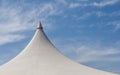 Looking up at the top of white tent against beautiful blue sky. Royalty Free Stock Photo