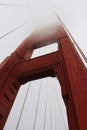Looking up a tower shrouded in fog on the Golden Gate Bridge in San Francisco, California Royalty Free Stock Photo