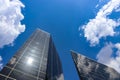 Looking up at modern buildings with reflections and a very blue sky with fluffy clouds Royalty Free Stock Photo