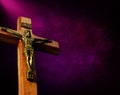 Looking up at wooden cross with Jesus ahead beam of light on purple