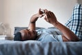 Looking at what my friends got up to last night. a handsome young man lying down on his bed and using his cellphone Royalty Free Stock Photo