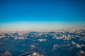 Looking through the window aircraft during flight a snow covered Italian and Osterreich Alps with blue sky without clouds Royalty Free Stock Photo