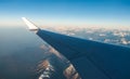 Looking through the window aircraft during flight a snow covered Italian and Osterreich Alps with blue sky without clouds Royalty Free Stock Photo