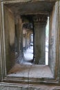 Looking through a window at stone pillar in famous histroical angkor wat ruins, cambodia Royalty Free Stock Photo