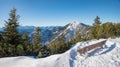 Lookout place with bench, view to Heimgarten mountain and bavarian alps in winter