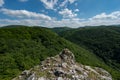 Lookout with a rock in the foreground of green leafy forests and hills in the Slovak Little Carpathian Mountains