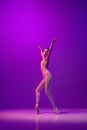 Studio shot of beautiful school age girl, ballet dancer dancing  on purple background in neon light. Art, grace Royalty Free Stock Photo