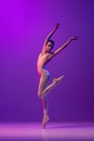 Studio shot of beautiful school age girl, ballet dancer dancing  on purple background in neon light. Art, grace Royalty Free Stock Photo