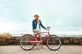 this looks like a good place to stop. a cheerful young getting ready to ride her bicycle while looking in a certain