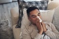 Looks like Im going to go through many tissues today. a young man blowing his nose while feeling sick at home. Royalty Free Stock Photo