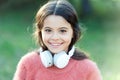 She looks like a music lover. Adorable little girl outdoor. Little girl child wearing headphones. Happy child enjoy Royalty Free Stock Photo