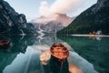 Looks like sun goes down. Wooden boats on the crystal lake with majestic mountain behind. Reflection in the water