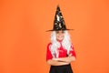 Looks perfect. trick or treat. supernatural charmer gray hair. kid enchantress orange background. happy halloween. magic