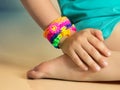 Loom bracelets on child hand close up.Rubber colorful wrist accessories.