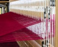 A loom set up with red wool warp threads ready for weaving Royalty Free Stock Photo