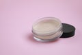 Loose face powder on pink background, space for text