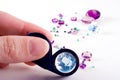 Loose gems,fingers and loupe Royalty Free Stock Photo