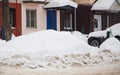 A loose snowdrift by the road against the backdrop of a city street with cars Royalty Free Stock Photo